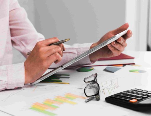 Compensação tributária sendo analisada em tablet com relatórios financeiros, gráficos e cálculo de impostos para gestão fiscal empresarial.