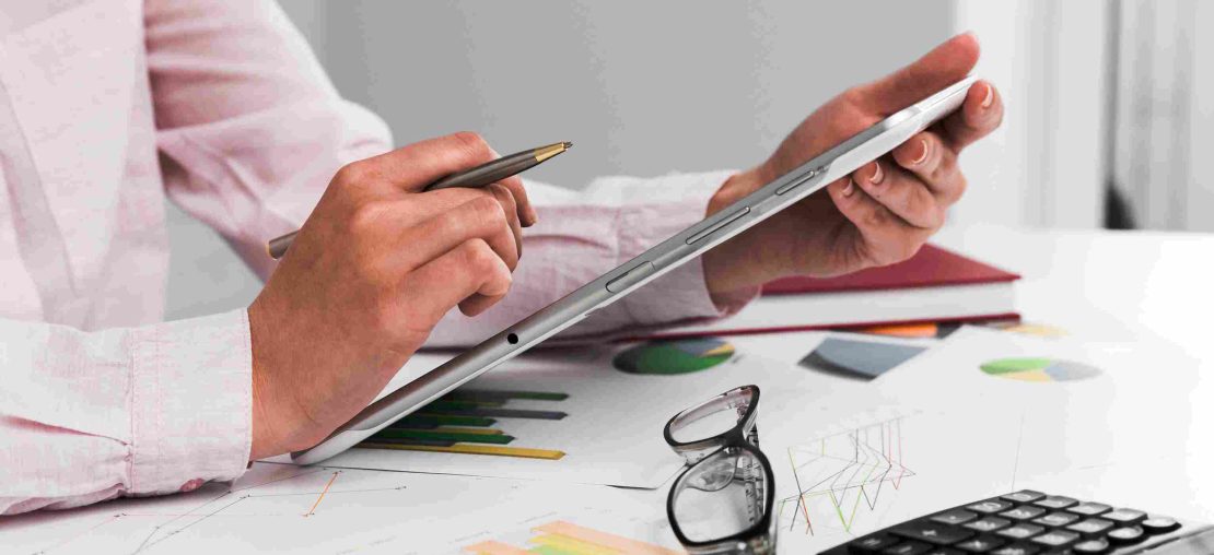 Profissional analisando relat&oacute;rios financeiros em tablet na contabilidade digital.